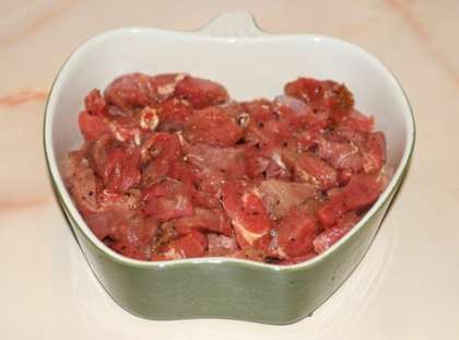 Дно и бока формы смажьте маслом (растительным или оливковым) и выложите в неё мясо.