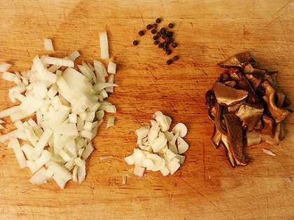 Приготовьте соус. Как можно мельче порежьте половину луковицы, зубчик чеснока и белый гриб (среднего размера). Если у вас нет белых грибов, можете использовать лисички или шампиньоны. В таком случае добавьте в соус несколько капель трюфельного масла, чтобы блюдо приобрело грибной аромат. Белый гриб даст такой запах и без трюфельного масла.