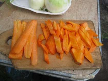 Пока на костре варится курица, почистите лук и морковь. Морковь нарежьте крупными пластинками, а лук нарежьте толстыми полукольцами толщиной около 1 см. При этом оставьте одну луковицу, она понадобится в конце приготовления шурпы.