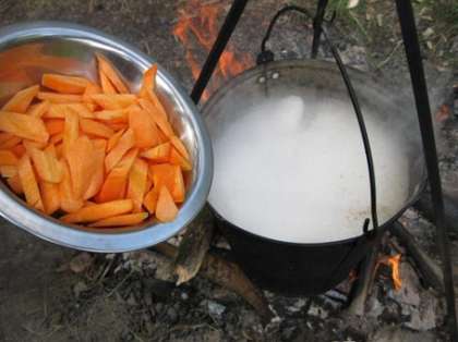 Когда пройдет 10 минут с момента закипания воды, выложите в ведро подготовленную морковь.