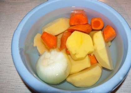 А пока вода в кастрюле закипает, подготовьте овощи. Почистите и промойте картофель, морковь и репчатый лук. Затем крупно нарежьте морковь, а картофель разрежьте пополам. Лук резать не нужно. Помните, что для шурпы все овощи должны быть порезаны крупными кусками, т.к. этим, и не только, она отличается от обычного супа.