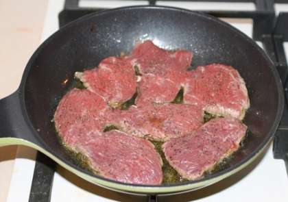 Разогрейте немного растительного масла в сковороде и обжарьте мясо с обеих сторон, поперчив его с каждой стороны. Мясо при жарке даст влагу, поэтому не нужно добавлять много растительного масла в сковороду. Крышкой не накрывайте, т.к. нужно чтобы влага выпарилась. Мясо нужно жарить почти до готовности, а не до полного приготовления.