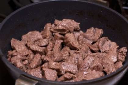 В отдельной сковороде разогрейте растительное масло и обжарьте в нем говядину на среднем огне, мясо должно слегка подрумянится.