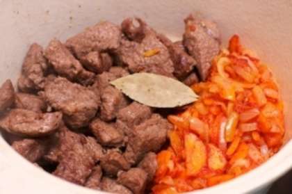 Выложите мясо и овощи в глубокую кастрюлю с толстым дном. Добавьте щепотку соли, лавровый лист и душистый перец.