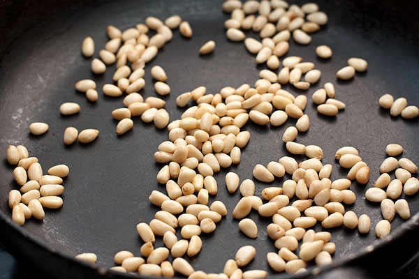 Горсть кедровых орешков поджарьте на сухой сковороде, помешивая, чтобы они зарумянились.