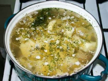 Добавьте картошку с грибами к курице. Варите до тех пор, пока не приготовится картофель. А пока нарежьте тонкими кольцами лук, обжарьте его в растительном масле до золотистого оттенка, затем посыпьте жареный лук мукой, перемешайте, периодически встряхивайте сковороду. Добавьте к курице кубики перца, лук и варите ещё несколько минут. Мелко порежьте оставшуюся зелень и также добавьте к курице (в конце).