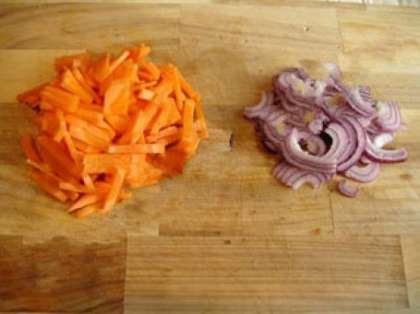 А пока жарится курица, нарежьте морковь соломкой или брусочками, лук нарежьте полукольцами.