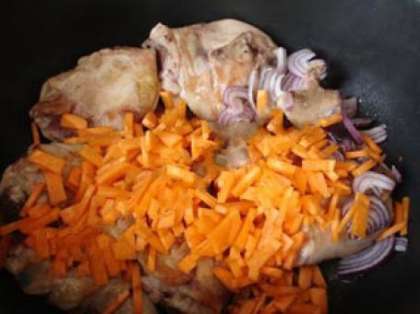 Выложите к курице морковь с луком, жарьте в течение 5-7 минут, помешивая. Затем добавьте бульонный кубик, влейте воду так, чтобы она покрывала курицу. Тушите 30 минут, накрыв крышкой.