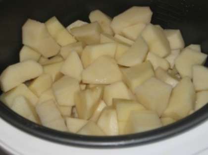 Мы будем тушить картофель в мультиварке с шампиньонами. Уложите продукты в мультиварку слоями. Каждый слой нужно немного посолить. Сначала выложите картошку, нарезанную небольшими кусочками.