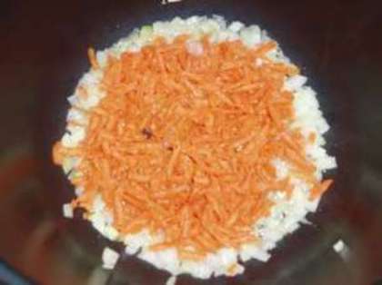 Пока жарится лук, очистите и натрите на крупной терке морковь. Затем также отправьте жариться к луку в мультиварку.