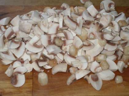 Нарежьте грибы. Грибы можно взять любые: шампиньоны, вешенки, опята и т.д. Хоть свежие, хоть консервированные. Только слейте маринад с консервированных грибов, не нужно его использовать в приготовлении.
