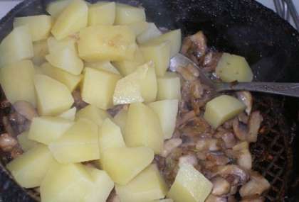 Когда картофель сварится, слейте воду и выложите картошку к грибам, перемешайте.