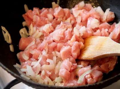 Нарежьте кубиками филе свинины, положите в сковороду к луку, перемешайте лопаткой. Тушите под крышкой на небольшом огне минут 30. Необходимо следить за количеством жидкости, мясо сразу выделит сок, а затем его впитает, если нужно – добавьте немного воды. Если у вас свинина жирная, можете жарить прямо на свином жиру, без добавления растительного масла.