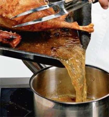 Приготовьте соус. Выньте готового гуся из духовки. Слейте жир в сотейник. Разведите куриным бульоном, доведите до кипения и варите на слабом огне 2-3 минуты.