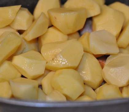 Крупно нарежьте картофель. Если у вас мелкая картошка просто разрежьте её пополам. Затем также выложите в утятницу, залейте водой до половины.