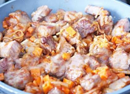 Нарежьте мясо на небольшие кусочки, обжарьте и смешайте с поджаренным луком.  Нарежьте кубиками морковь и добавьте к мясу с луком, также добавьте томатный соус и продолжайте жарить ещё минут 5-6. Если для приготовления данного блюда вы взяли свиные ребра, то они должны быть нежирными и свежими (не замороженными).