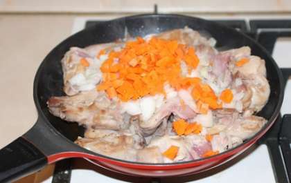 Убавьте огонь, выложите в сковороду лук и морковь. Перемешайте и готовьте 10-15 минут на среднем огне, накрыв сковороду крышкой.