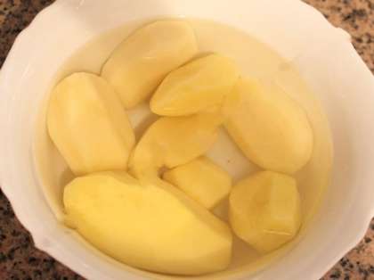 Почистите картошку, и составьте её в воде, чтобы не потемнела.