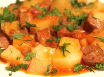 Перед тем как подать на стол готовое блюдо, посыпьте его свежей зеленью. Подавать тушеную картошку с мясом можно с солеными овощами или с салатом из огурцов и помидоров. 