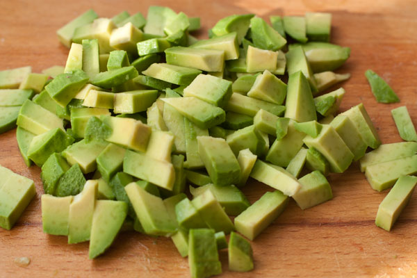 Спелый авокадо очистите, нарежьте кубиками, чуть крупнее огурца, слегка сбрызните лаймовым или лимонным соком и добавьте в салат.