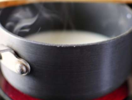 Параллельно поставьте кастрюлю с молоком. Посолите немного, добавьте сахар и масло в молоко. Закипятите молоко и снимите с плиты.