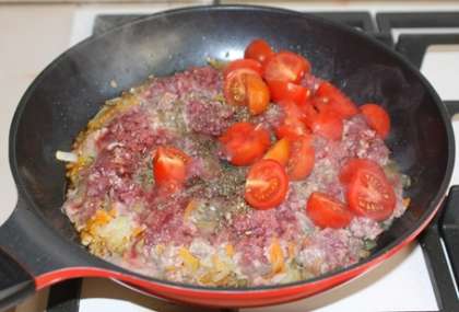 Выложите к овощам помидоры и фарш. Добавьте соль (1,5 ч.л.), итальянские травы, черный молотый перец и зиру. Хорошо перемешайте все и обжаривайте мясо 10-15 минут, разминая его вилкой.