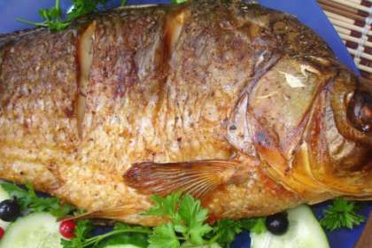 Готовую рыбу переложить в блюдо. Украсить кусочками огурца, можно добавить ягоды клюквы и пару веточек зелени. 