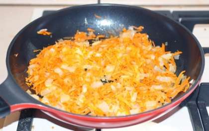 Разогрейте растительное масло на сковороде, положите туда лук и морковь, слегка пассируйте.