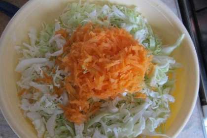 Натрите морковь на средней терке и добавьте к капусте. Мелко нарежьте лук.