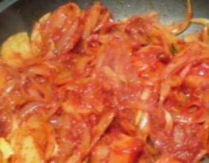 Затем обжарьте лук полукольцами и ломтики чеснока на сковороде. В конце залейте все это томатной пастой.