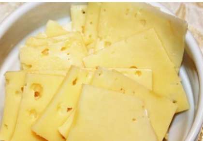 Приготовьте кусочек сыра. Выбирайте сыр не очень твердый, а главное не очень острый. Порежьте его поперек, широкими ломтиками.