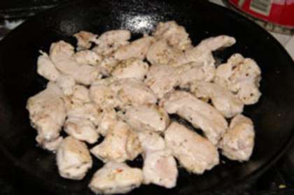 Разрежьте куриное филе на небольшие кусочки, немного посолите, посыпьте специями, например, можно использовать смесь перцев. Смажьте сковороду небольшим количеством растительного масла и обжарьте куски куриного филе.