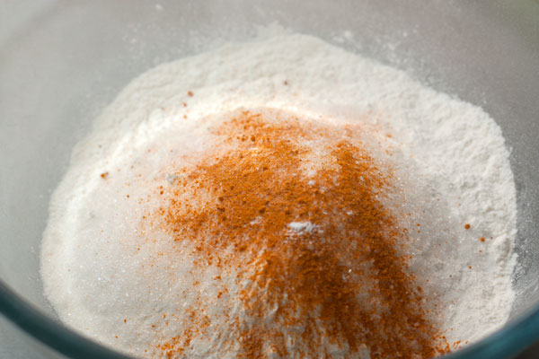 Просейте муку в миску, добавьте остальные сыпучие ингредиенты: соду на кончике ножа, соль, сахар. Для яркого цвета хорошо использовать куркуму.