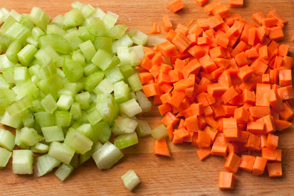 Пока рис варится, очистите и нарежьте небольшими кубиками сельдерей и морковь. 