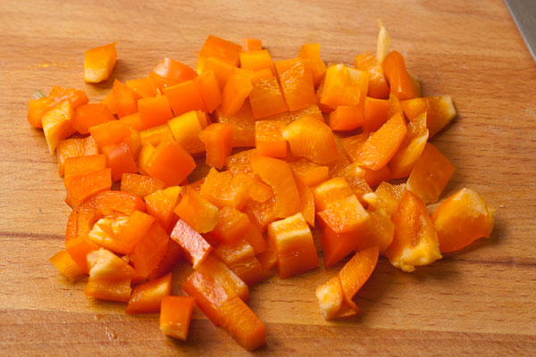 Нарежьте кубиками сладкий перец и бросьте в сковороду. 
