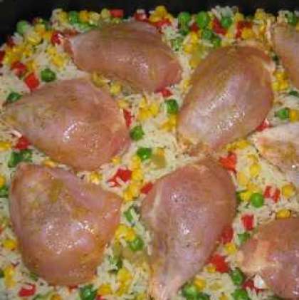Бедра куриные помойте и обсушите. Далее курицу посолите и  поперчите. Потом нужно добавить специи (оригано, тимьян, кориандр, карри). Выложите курицу в рис с овощами, так чтобы она немного утопала в смеси.
