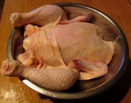 Для того чтобы приготовить фаршированную курицу, ее нужно помыть и обсушить. Отрежьте затем  жир внутри и хвостик. Далее удалите оставшиеся маленькие перышки, если такие имеются.