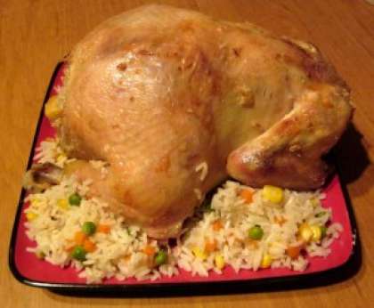 Подавайте фаршированную курицу на блюде. Оставшуюся начинку разложите вокруг. 