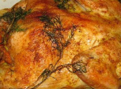 Далее выложите на курицу  зелень укропа, или петрушки (любую зелень, какую найдете). Поставьте ее в духовку и запекайте при температуре 200°С. Это займет где-то 1 час 25 минут. Вытащите готовое блюдо и подавайте на стол. 
