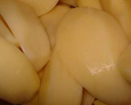 Очистите и помойте клубни картофеля. Обсушенный картофель разрежьте на четыре части.