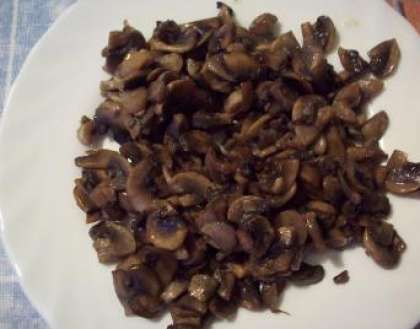 Почистите и помойте грибы. Порежьте их пластинками, и бросьте в разогретую сковороду тушиться. Налейте предварительно масло растительное. Снимите через 10 минут и остудите, Откиньте их на дуршлаг и отожмите грибы. Брать для рулета нужно только сухие грибы.