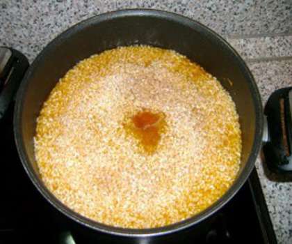 Заранее промываем рис в воде несколько раз для удаления лишней клейковины. Насыпаем рис сверху на смесь мяса и овощей, разравниваем его лопаткой по поверхности, делаем в середине ямку и вставляем одну головку чеснока целиком.