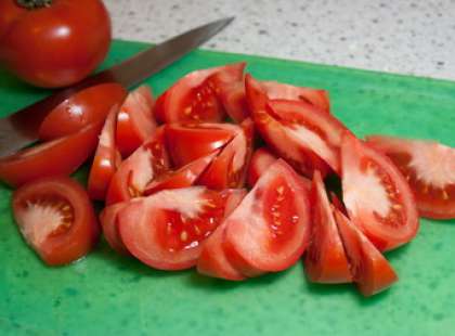 Далее возьмите помидоры. Вымойте томаты, обсушите. Покрошите их на ломтики (крупные).