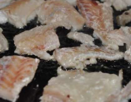 Разморозьте рыбу. Помойте ее и обсушите немного. Затем возьмите нож и нарежьте ее на куски (крупные). После этого возьмите муку и насыпьте в тарелку, обваляйте в ней кусочки филе, добавьте соли чуть, поперчите немного рыбу. Разогрейте сотейник и налейте туда растительное масло. Обжарьте в нем до золотистой корочки кусочки трески.