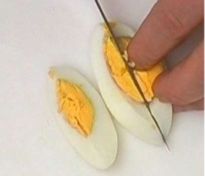 Сваренные яйца вкрутую, следует остудить. Как только они остынут, очистите их. Порежьте готовые яйца также дольками.