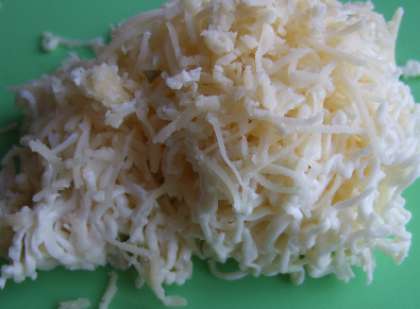 Сыр сливочный плавленый нужно натереть на мелкую терку. Затем выложить в мисочку и добавить к нему нашинкованный зеленый лук, и измельченный редис и яйцо.