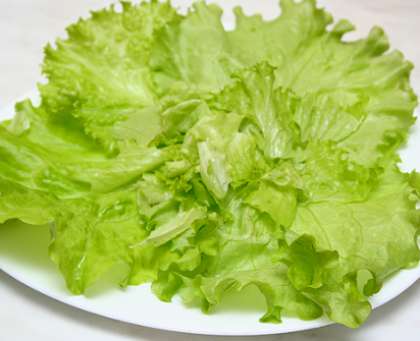 Кочан зеленого листового салата вымыть. Хорошо обсушить, а затем разобрать на листочки и положить их на плоскую тарелочку (салатник), в центре.