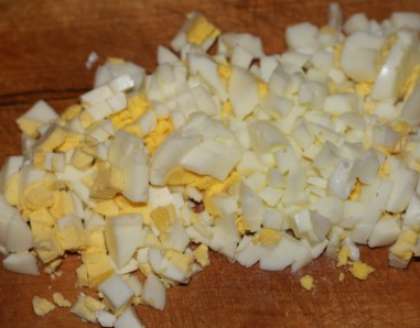 После сыра следует отварить яйца. Отваренные вкрутую яйца остудите, очистите от скорлупы. Потрите на их терке точно так же, как и сыр.