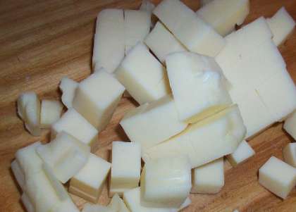 Затем нежный сыр моцаррелу также аккуратно порежьте на кусочки.