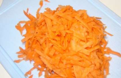 Ополосните почищенную морковь. Обсушите плоды. Затем возьмите терку для овощей по-корейски и натрите морковь. Посолите (чуть-чуть), потом разомните слегка.